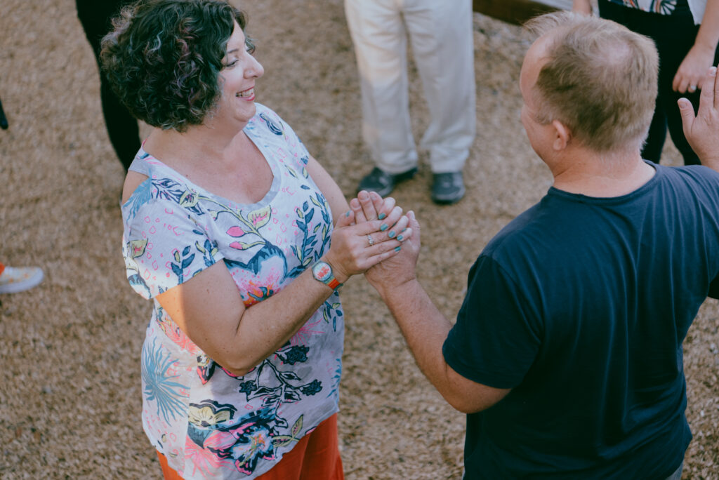 A female facilitator takes a male attendee by the hand